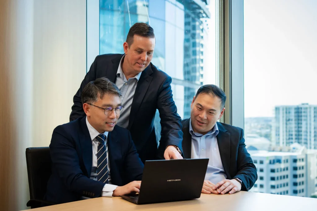 Managing Directors in a high-tech office reviewing a real-time blockchain analytics dashboard on a large, glowing monitor.