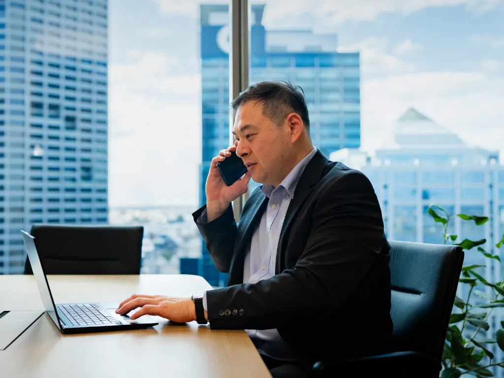 A financial professional in a high-tech office using a multi-screen setup to monitor digital asset markets and cryptographic custody protocols.